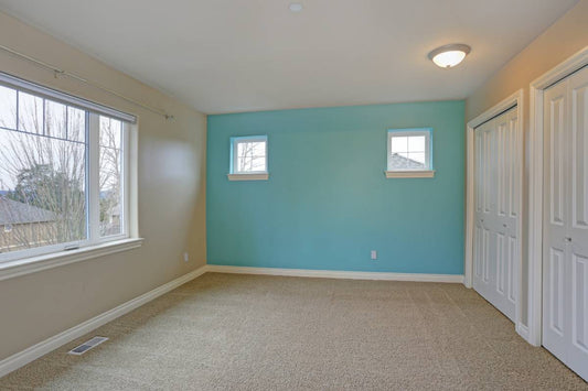 An empty room in a new home with a bright blue-green accent wall at Red Star Paint near Bloomfield Ave. Montclair, NJ